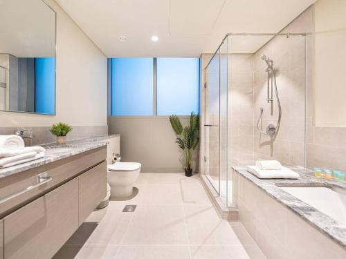 a bathroom with a shower and a toilet and a sink at Panoramic Full Fountain,Opera& burj Sky View 4BR APT in Dubai