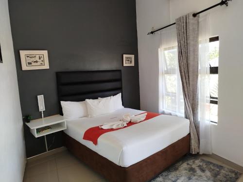 a bedroom with a bed with a red towel on it at Shalakwe Hills-Inn Guesthouse Kasane in Kasane