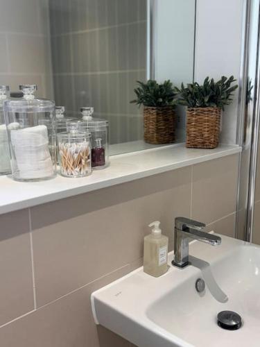 a bathroom with a sink and a mirror and towels at Coastal Retreat at Rest Bay, Porthcawl in Porthcawl