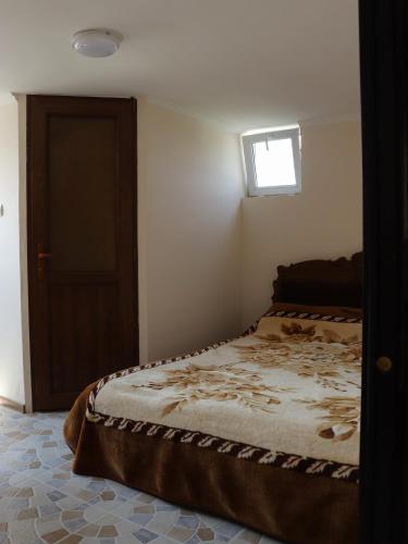 a bedroom with a bed with a window and a door at Առանձնատուն Սուրբ Հովհաննեսի և Թռչկանի տարածքում in Tsaghkaber