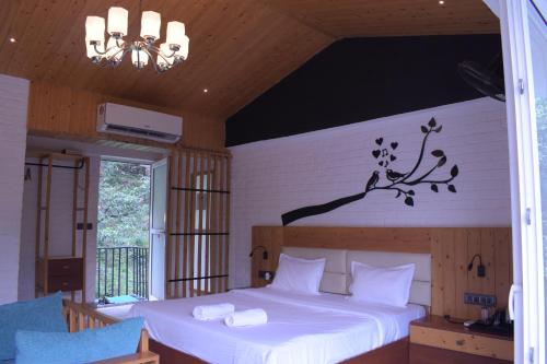 a bedroom with a bed with a branch on the wall at Julley Commune Rishikesh in Rishīkesh
