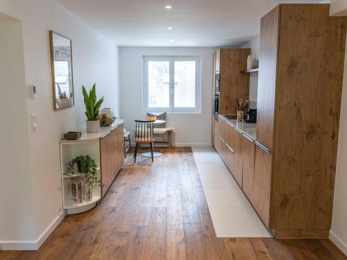 une grande cuisine avec des placards en bois et une table dans l'établissement Grand Appart Luxe 8 Pers Centre-ville avec Parking - FR-1-234-320, à Cauterets