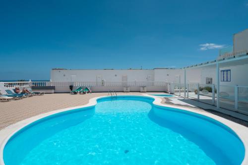 a swimming pool on top of a building at Splendor, piscina, junto a la playa, terraza privada con vistas al mar y preciosos atardecer in Puerto del Carmen
