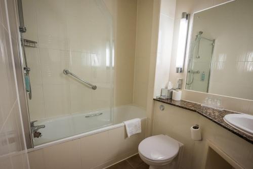 a bathroom with a tub and a toilet and a sink at The Townhouse Manchester in Manchester