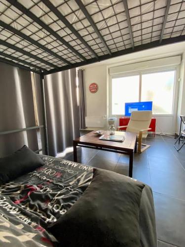 une chambre avec un lit et une table et une salle à manger dans l'établissement Le Nid Douillet au Pied des Remparts d'Avignon, à Avignon