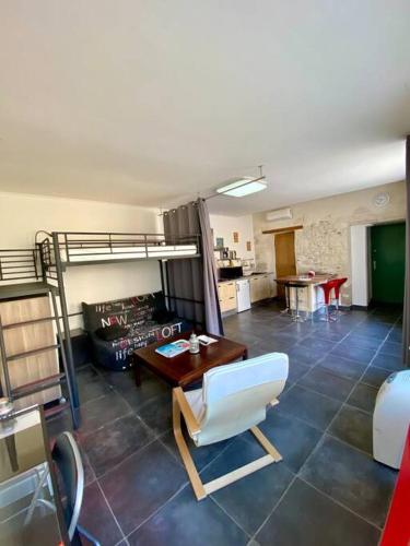- un salon avec des lits superposés et une table dans l'établissement Le Nid Douillet au Pied des Remparts d'Avignon, à Avignon