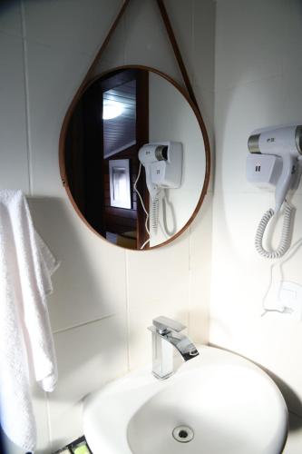 a bathroom with a mirror and a sink at Pôr do Sol Ilha do Mel Pousada e Receptivo in Ilha do Mel