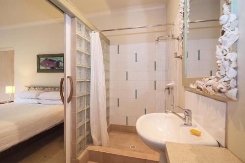 a bathroom with a sink and a bedroom with a bed at Sea & Soul Beachside Apartments in Prevelly