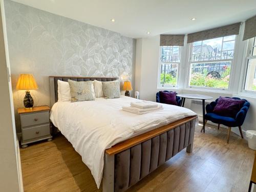 a bedroom with a large bed and a table at The Avonmore Olympia in London