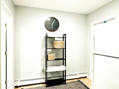 a clock on a wall next to a shelf at Lux Designer Home with Gaming Rm in Jersey City