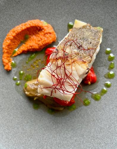 a plate of food with a piece of meat and vegetables at Aldea Rural y Gastro Restaurante Casona de Labrada in Labrada