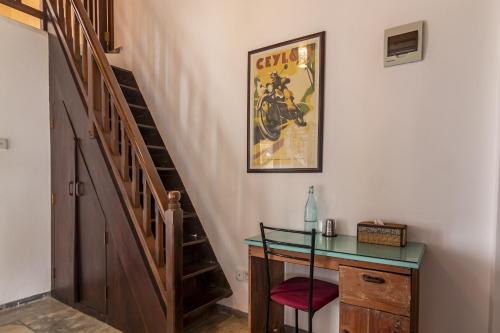 a staircase with a desk and a picture on the wall at Lion's Rest in Weligama