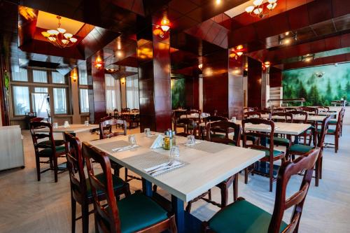 a restaurant with tables and chairs in a room at Bacolux Santis, Covasna in Covasna