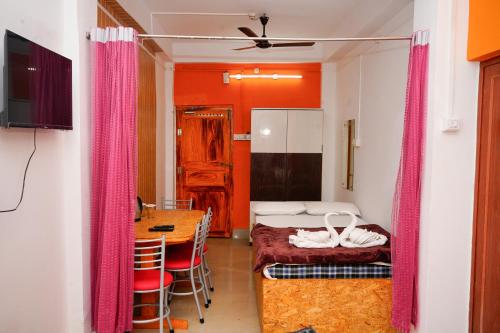 a room with a bed and a table in a room at Sea Pearl Homestay in Port Blair