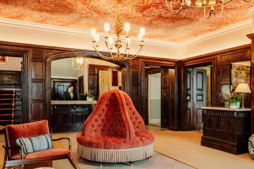 a living room with a red chair and a mirror at Ansty Hall in Coventry