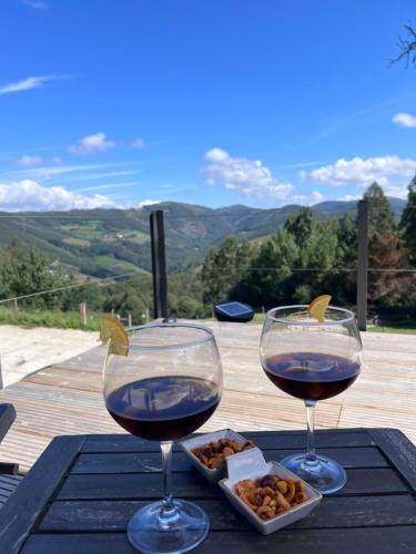 two glasses of wine and a plate of food on a table at Aldea Rural y Gastro Restaurante Casona de Labrada in Labrada