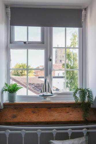 a window with two potted plants on a window sill at Riverside Cottage in Tewkesbury