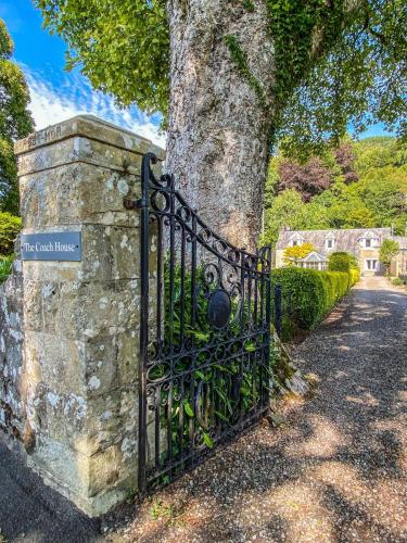 a wrought iron gate next to a tree at The Coach House in Saint Fillans