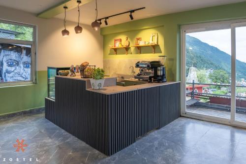 a kitchen with a counter in a room with a window at Zostel Dharamkot in McLeod Ganj