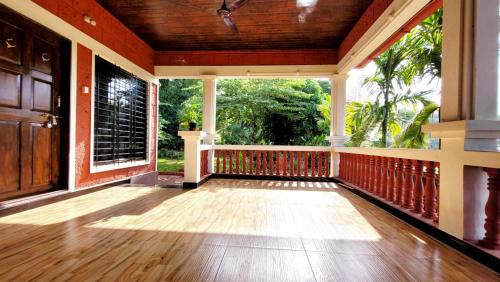an empty porch of a house with a wooden floor at Aranya Home Stay Malvan in Chaoka