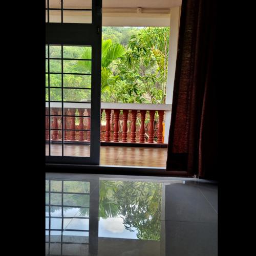 an open window with a view of a reflection in the water at Aranya Home Stay Malvan in Chaoka