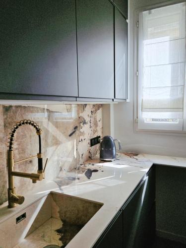 un comptoir de cuisine avec un évier et une fenêtre dans l'établissement Luxury apartment at heart of Paris, à Paris
