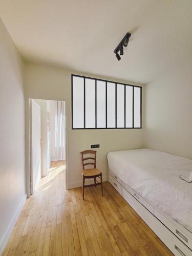 une chambre avec un lit et une chaise dedans dans l'établissement Luxury apartment at heart of Paris, à Paris