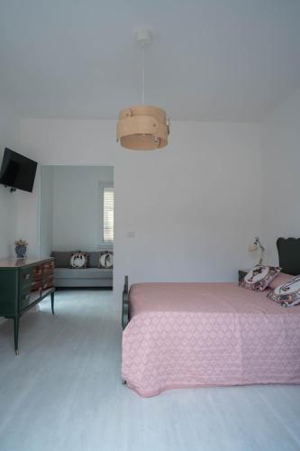 a bedroom with a pink bed and a tv at Avi Rooms in Chiaramonte Gulfi