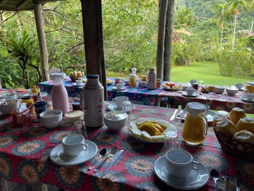 une table avec une nappe sur laquelle se trouve de la nourriture dans l'établissement Vila do Teteco Ecopousada, à Parati