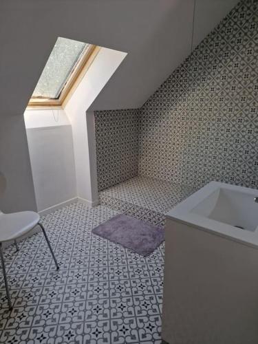 une salle de bain avec un lavabo et une fenêtre dans l'établissement pavillon en pleine nature, à Brains-sur-Gée