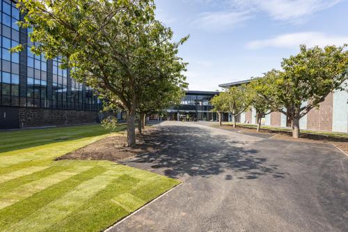 an empty street in front of a building with trees at The SPACE To Stay, St Andrews in St. Andrews