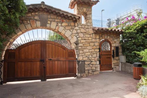 - une entrée pour une maison en pierre avec une porte en bois dans l'établissement RARE! 2-Br with Pools Beach Access Private Parking, à Cannes