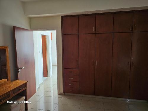 a large room with wooden cabinets and a hallway at King's Holiday Apartments in Paphos City