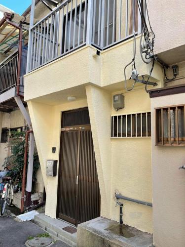 a building with a brown door on the side of it at AnNam Stay Osaka Airport - whole two story house rental in Toyonaka