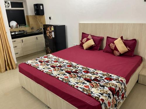 a bedroom with a large bed with a red comforter at VisitorStayInn in Vrindāvan