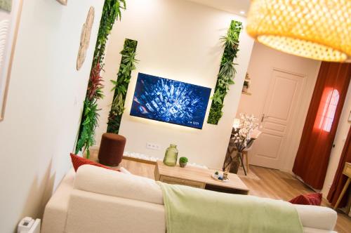 a living room with a couch and plants on the wall at L'atelier vert - Suite Luxe, SPA, Proche Hypercentre - Classé 4 étoiles in Troyes