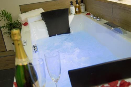 a table with two glasses and a bottle of wine at L'atelier vert - Suite Luxe, SPA, Proche Hypercentre - Classé 4 étoiles in Troyes