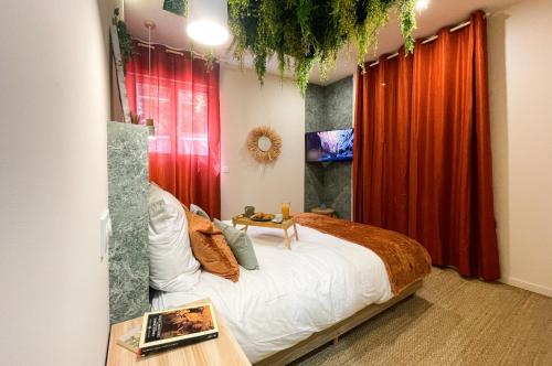 a bedroom with a bed and a red curtain at L'atelier vert - Suite Luxe, SPA, Proche Hypercentre - Classé 4 étoiles in Troyes