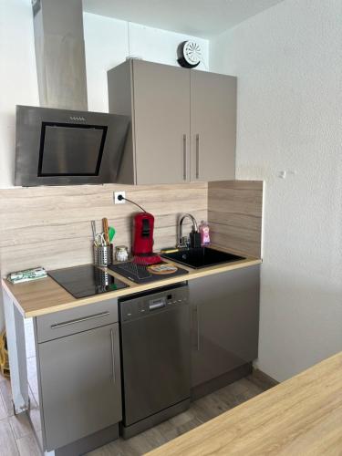 une petite cuisine avec un évier et un micro-ondes dans l'établissement Studio cabine vue mer Agde Ile des pecheurs, au Cap d'Agde