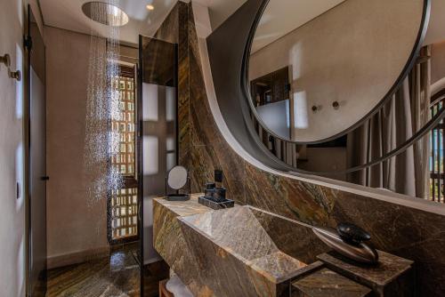 a bathroom with a large mirror and a sink at The Echo Of The Sea - Beachfront Luxury Villa in Skalotí