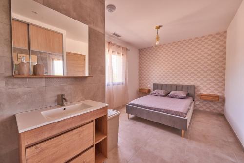 a bathroom with a sink and a bed in a room at Villa vue exceptionnelle in Servian