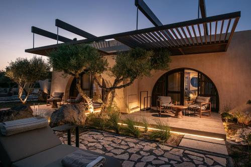 a house with a patio with a table and chairs at The Echo Of The Sea - Beachfront Luxury Villa in Skalotí