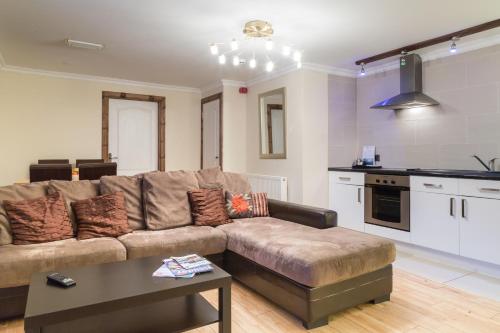 a living room with a couch and a kitchen at Lamlash Bay Hotel in Lamlash