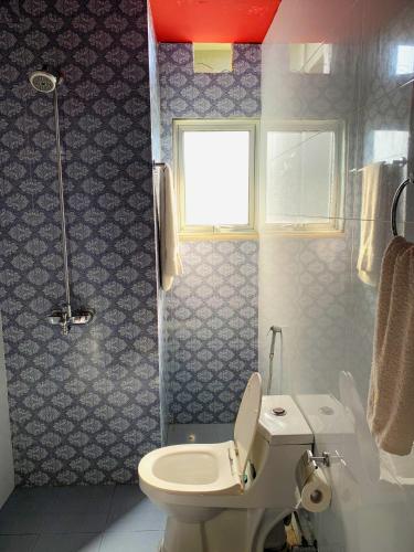 a bathroom with a toilet and a sink and a window at Regal Suite by StayMehman in Rawalpindi