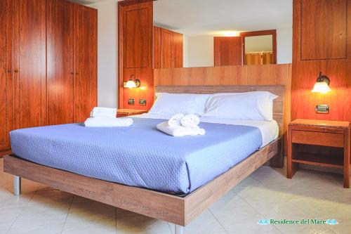a bedroom with a large bed with towels on it at Residence del mare in Ardea
