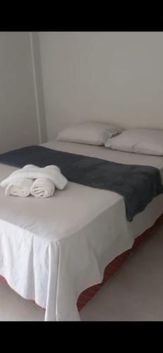 a bed with two white towels on top of it at Villagio Coqueiro in Luis Correia