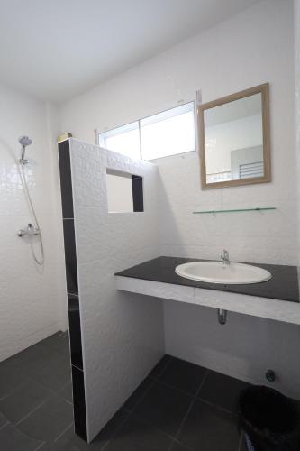 a white bathroom with a sink and a mirror at Fantasy Hill Bungalow in Kata Beach
