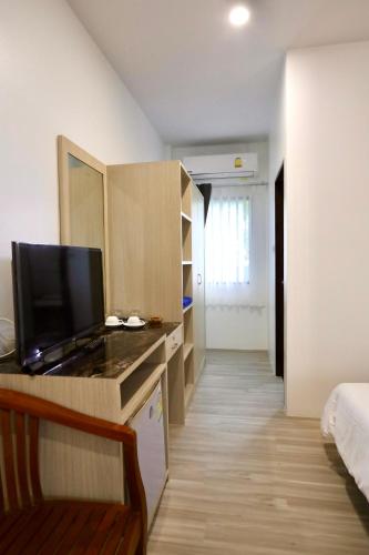 a room with a bed and a desk with a television at Fantasy Hill Bungalow in Kata Beach