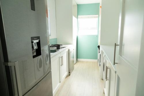 a kitchen with blue walls and white cabinets at Fijnbos in Pringle Bay