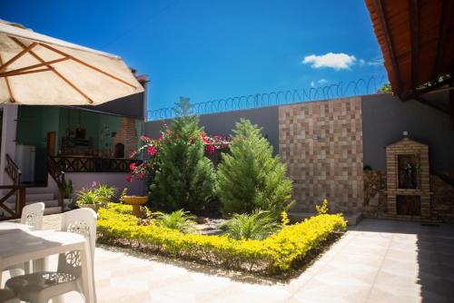 a patio with a garden with trees and flowers at Casa de Serra Vila Viçosa in Viçosa do Ceará